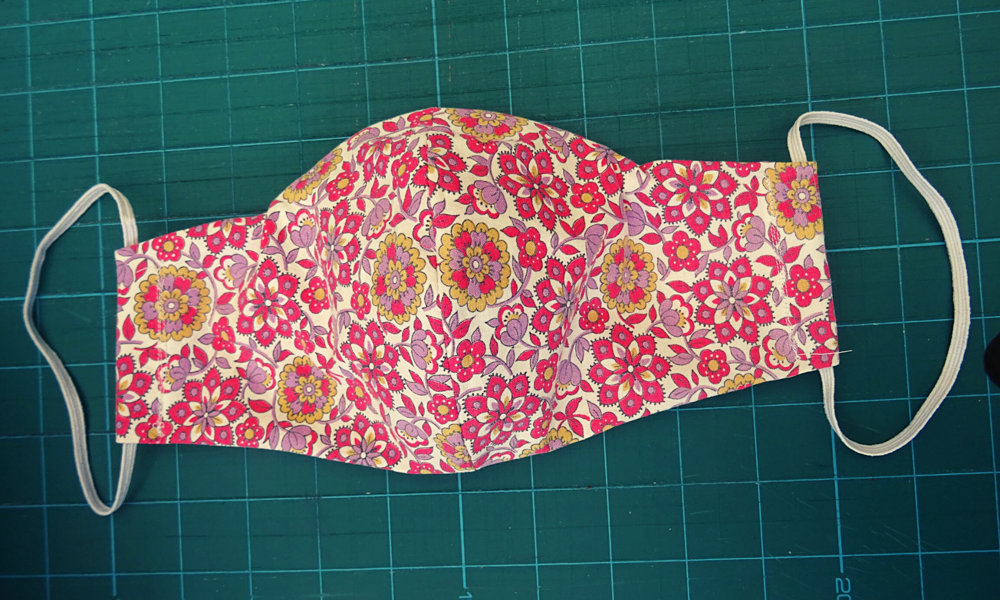 overhead photo of fabric face mask on a cutting mat