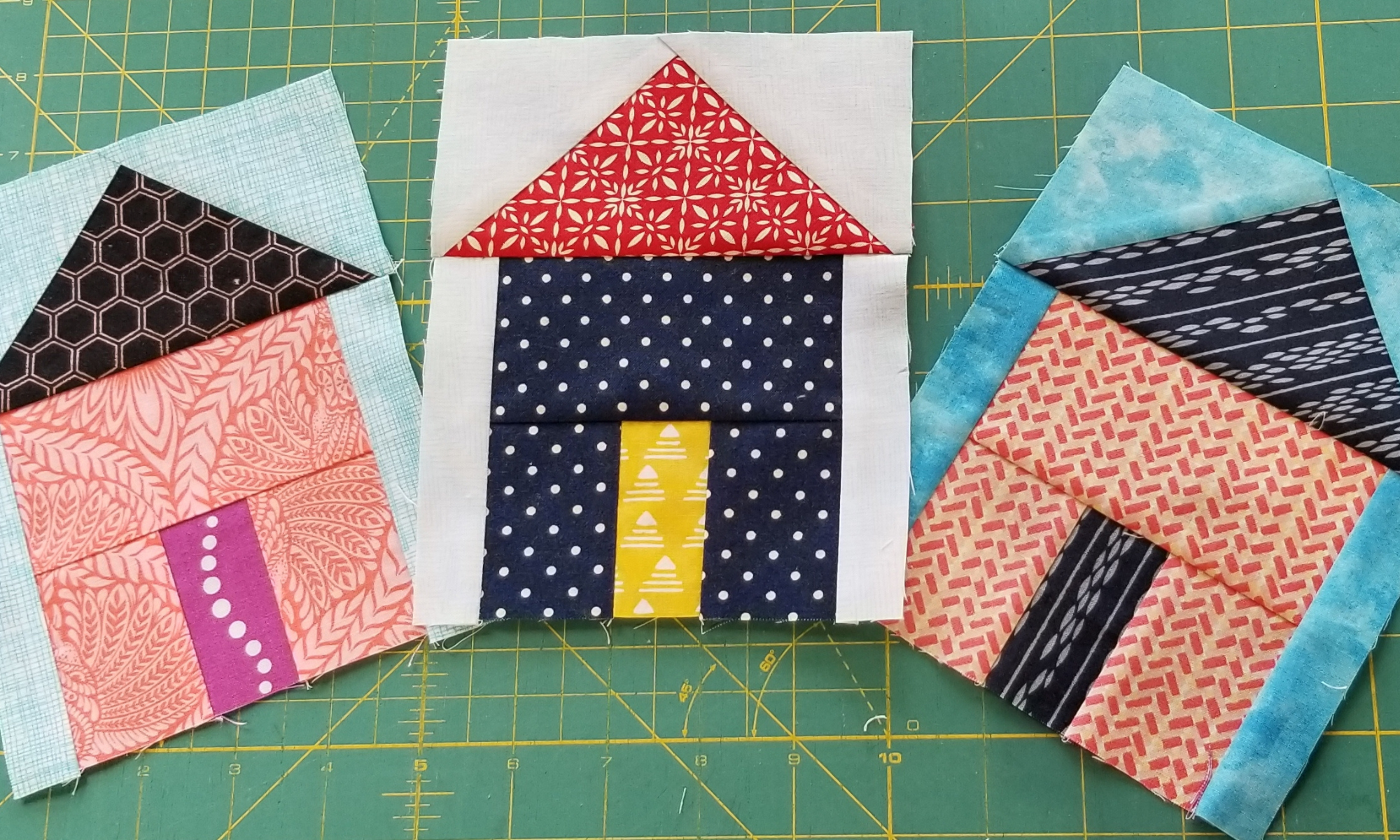 three house blocks on a cutting mat